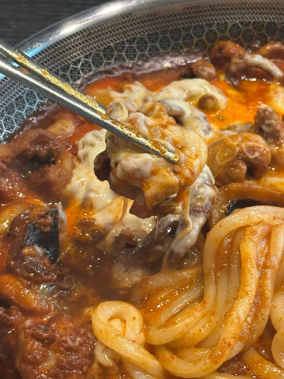 A piece of octopus dipped in melted cheese
