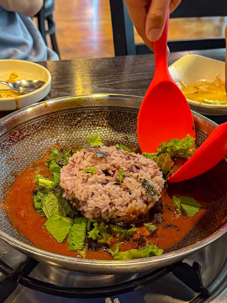 Fried rice being stir-fried with vegetables and seaweed