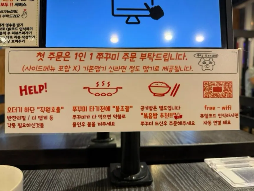 Menu board listing jjukkumi and noodle add-in options at Songjjujip