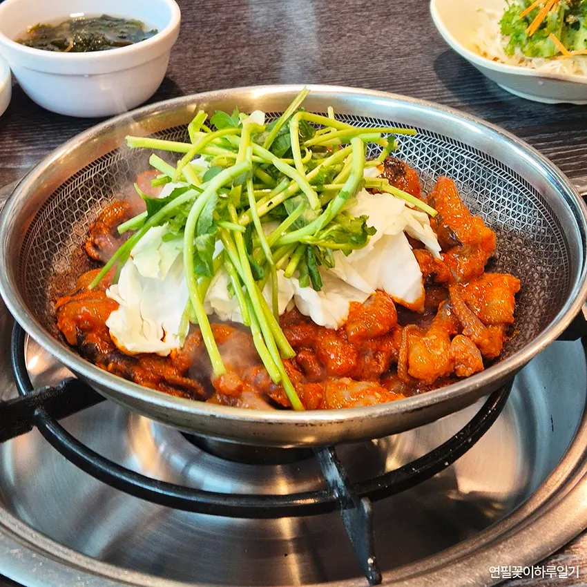 Pot of octopus stir-fry topped with minari and cabbage