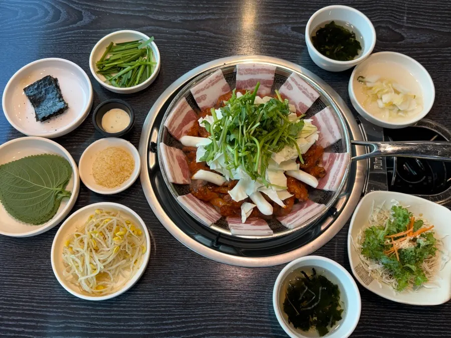 Full spread of basic side dishes: bean sprouts, perilla leaves, white kimchi, and more