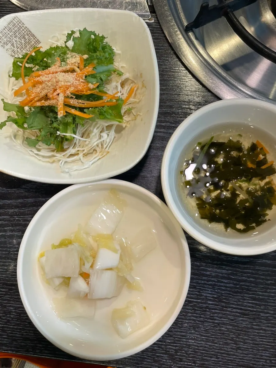 Mesa de guarniciones con sopa fría de algas y kimchi blanco