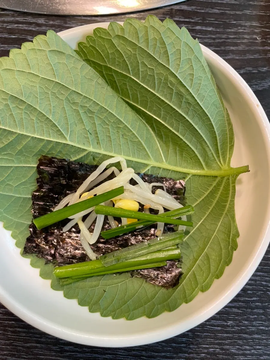 Preparación del envuelto con hoja de perilla, alga y brotes de soja
