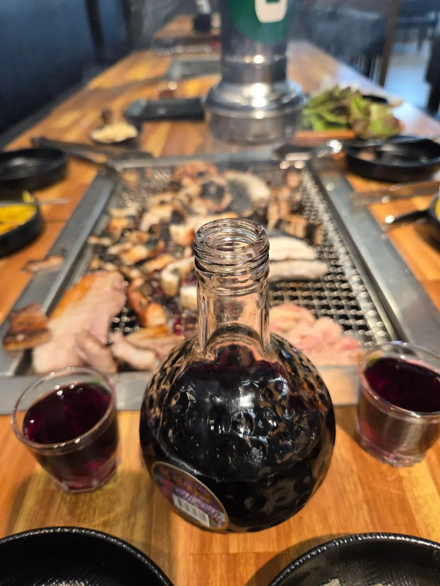 A glass of bokbunja wine with grilled eel