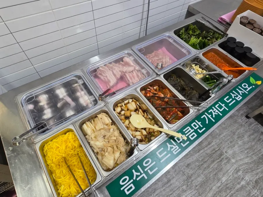쌈채소와 반찬이 놓인 셀프바 구성