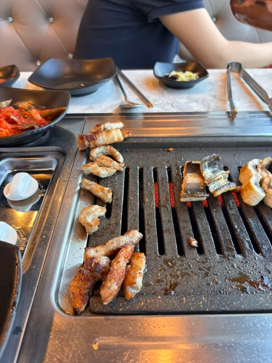 Chicken neck meat and pork belly cooking on the grill