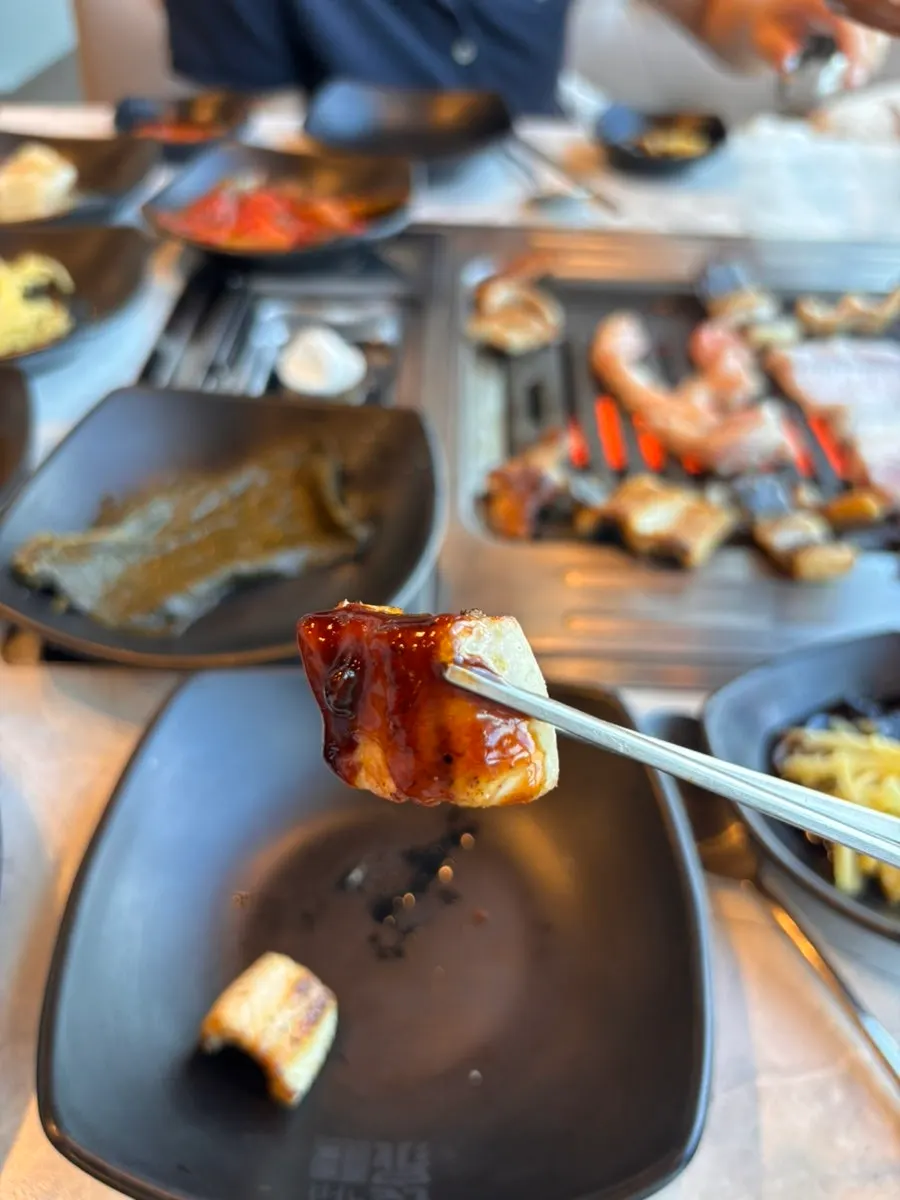 A piece of pork belly picked up with chopsticks