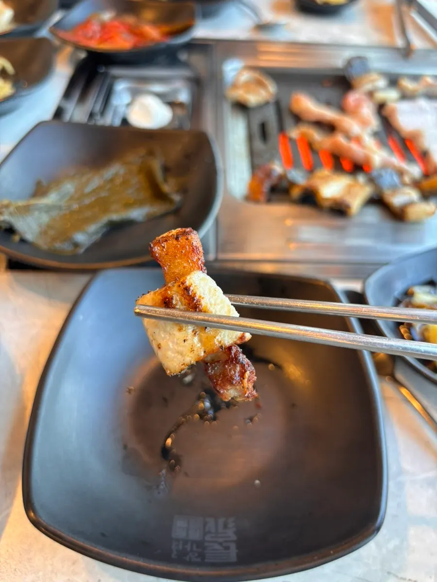 A piece of eel topped with sauce and ginger
