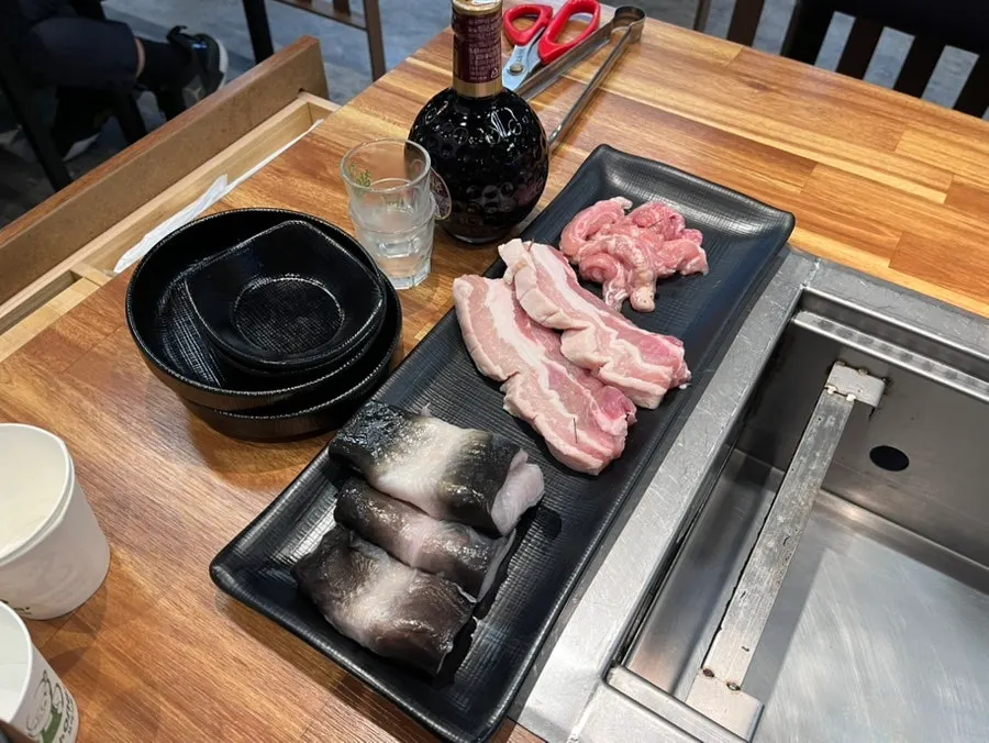Plate of chicken neck and pork belly served alongside the eel