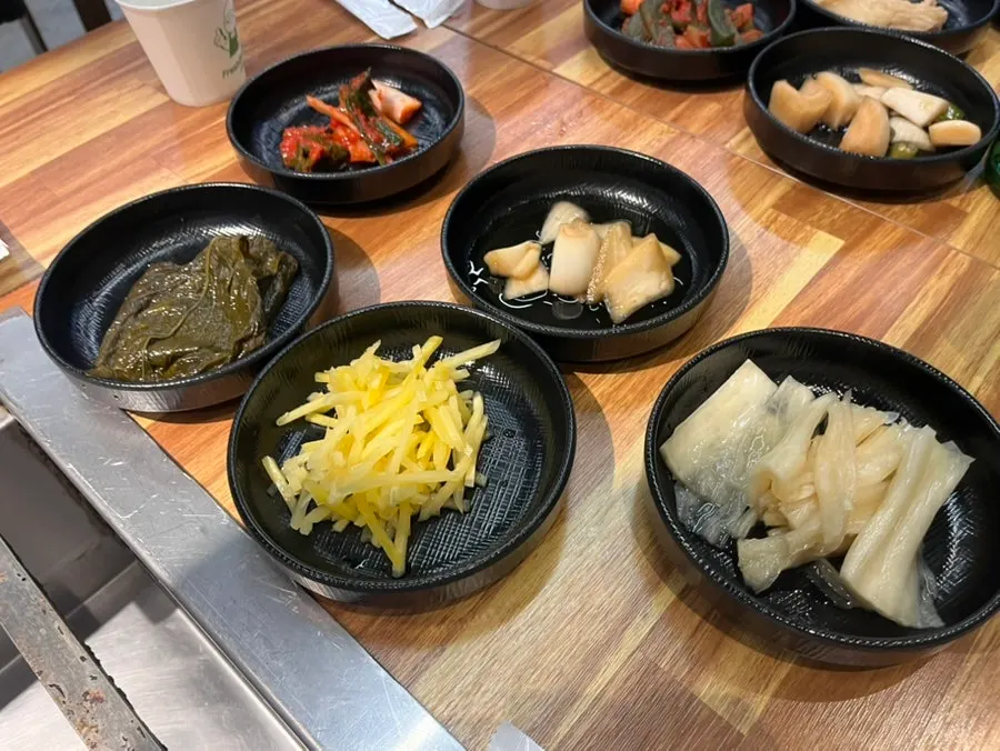 Side dish spread of ginger, pickles, perilla leaves, and kimchi