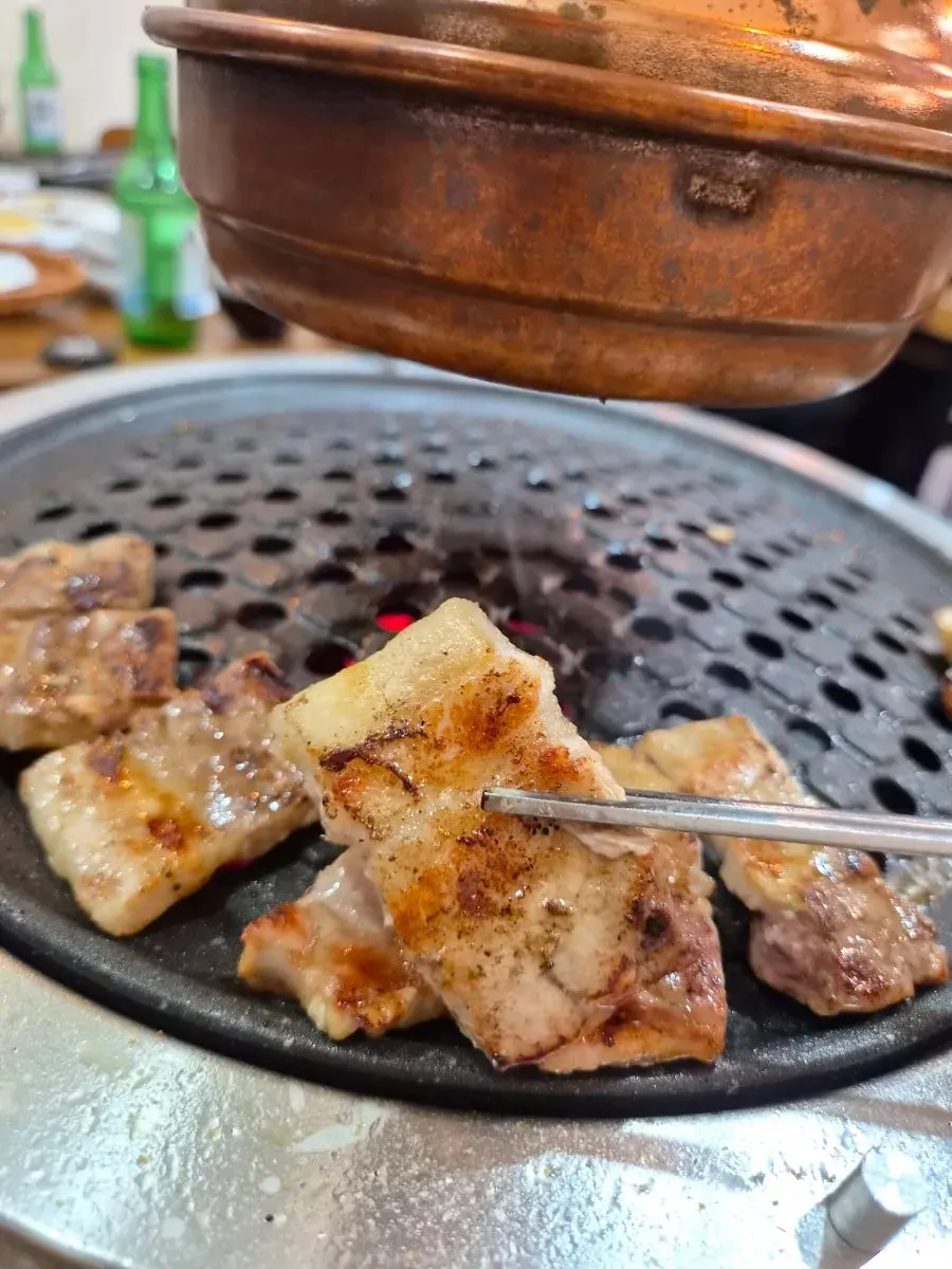Whole pork belly grilling alongside the eel
