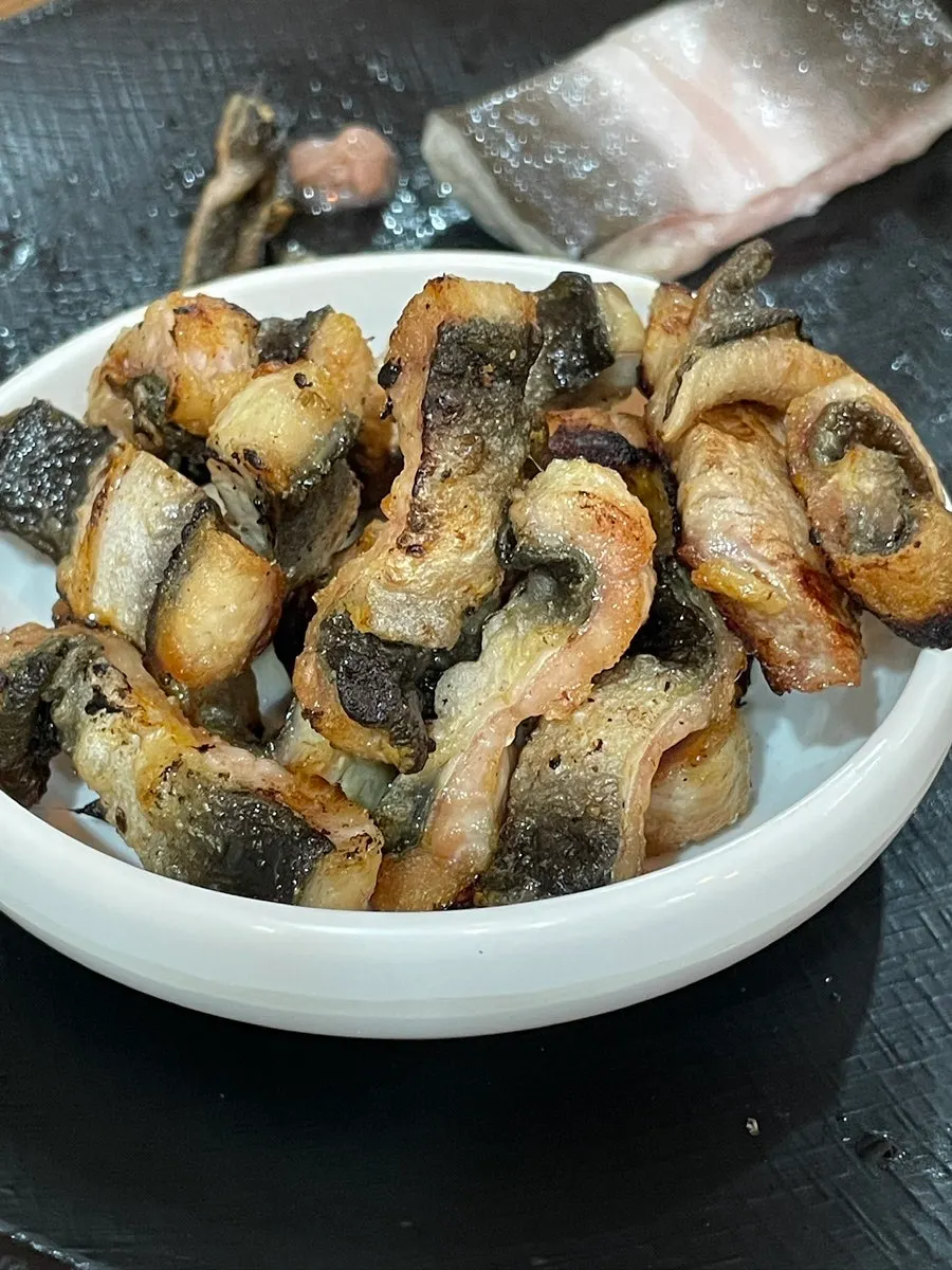 Eel and meat grilling together on the pan