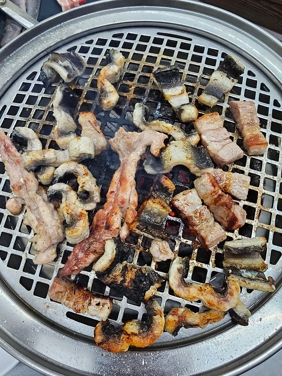 숯불 위에서 구워지는 장어와 삼겹살 닭목살