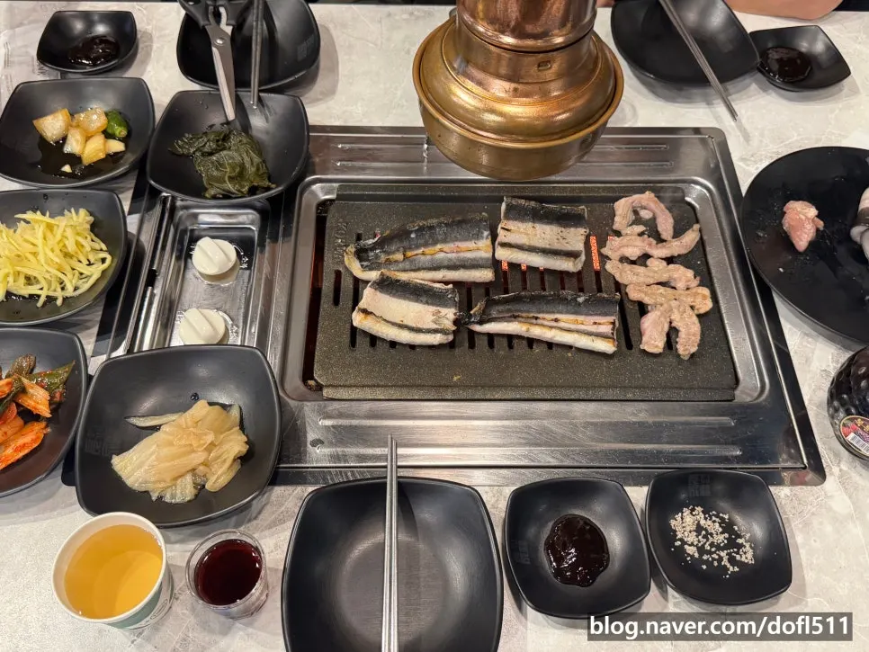 Full table spread with side dishes and bokbunja wine at the unlimited eel restaurant