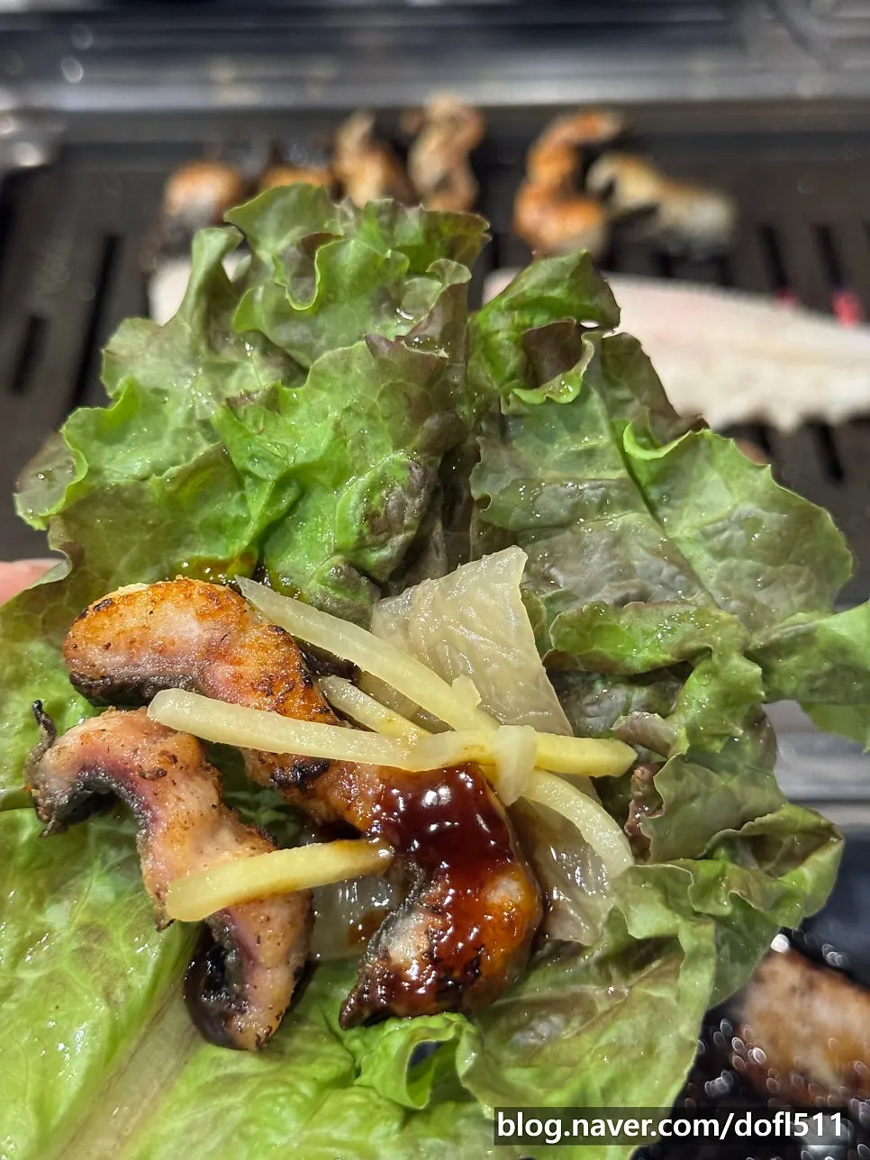 A bite of eel wrapped in lettuce