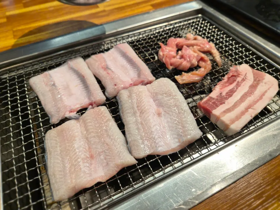 Fresh raw eel and pork belly on the grill