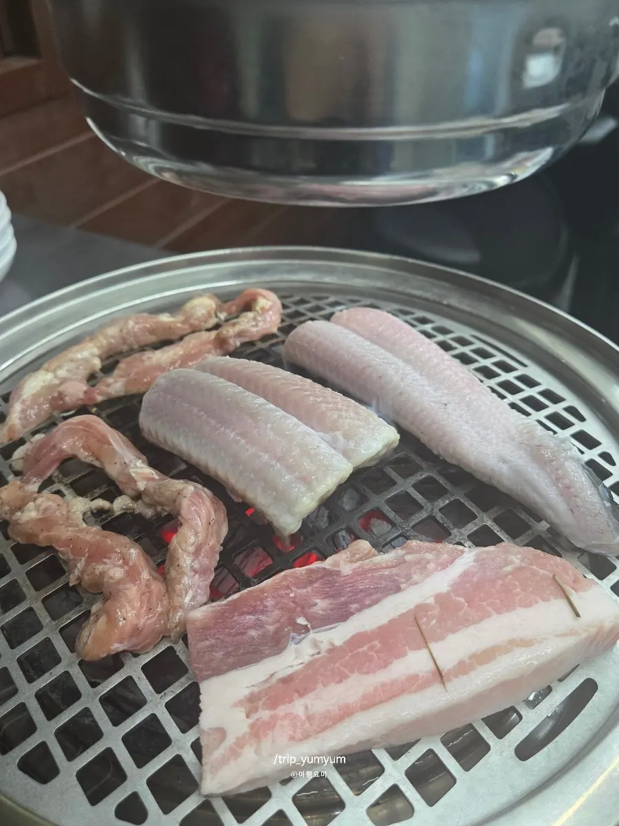 Eel, pork belly, and duck neck grilling together over charcoal