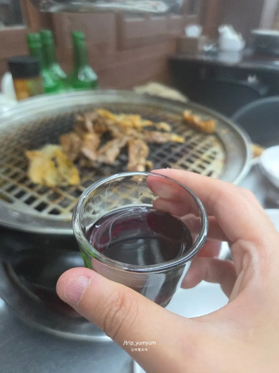 A piece of eel with a glass of bokbunja wine