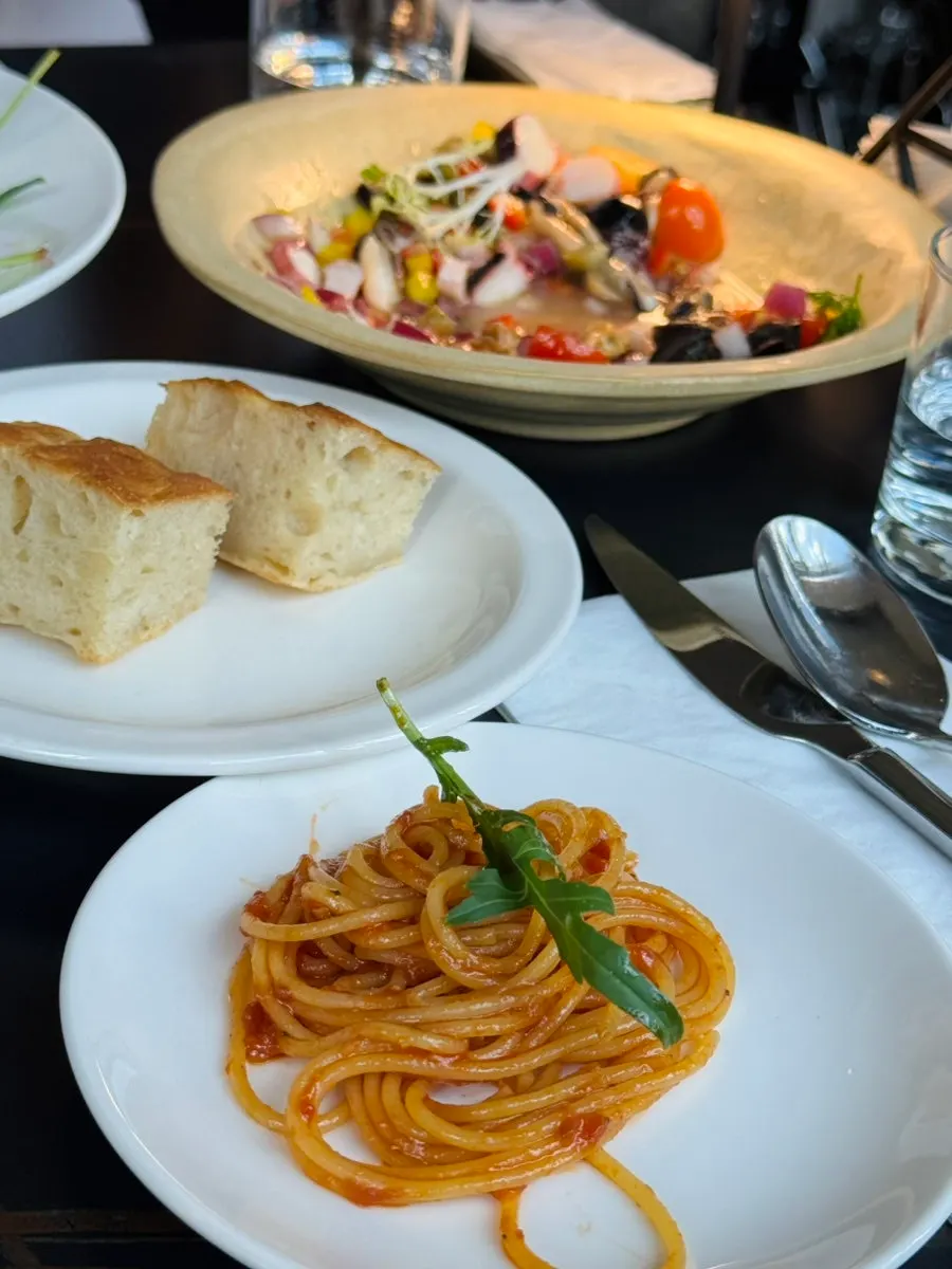 Lifting a forkful of puttanesca pasta