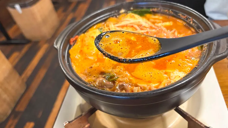 국자로 떠올린 곱창전골 국물
