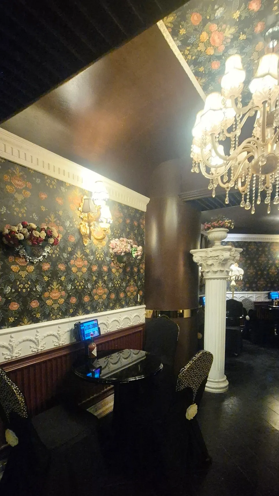 Wall decorated with floral-pattern wallpaper and classic framed art