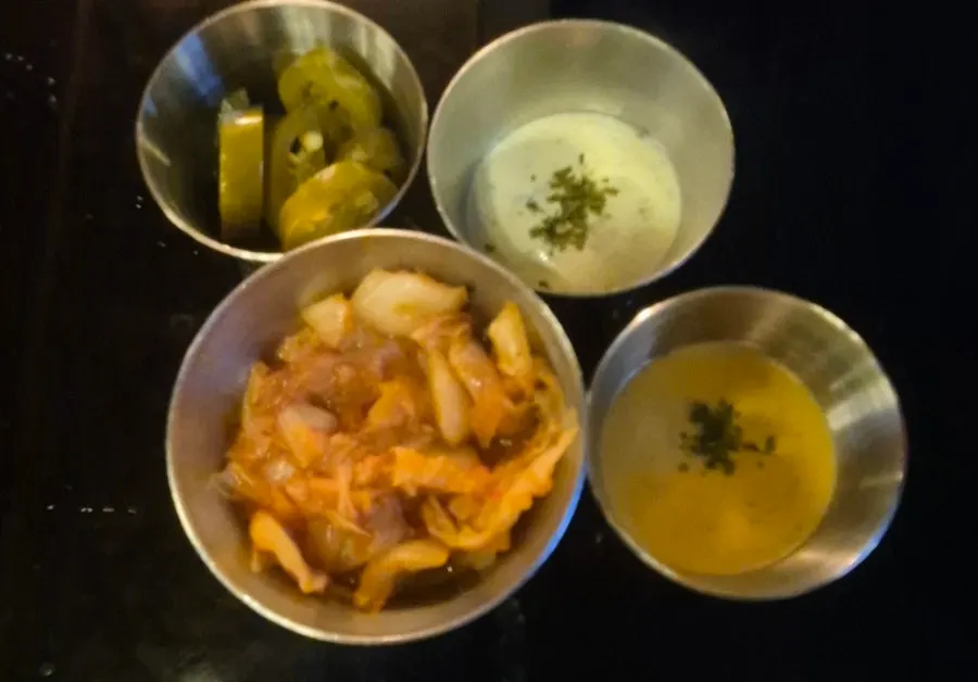 Pickles, sauces, and kimchi served as sides