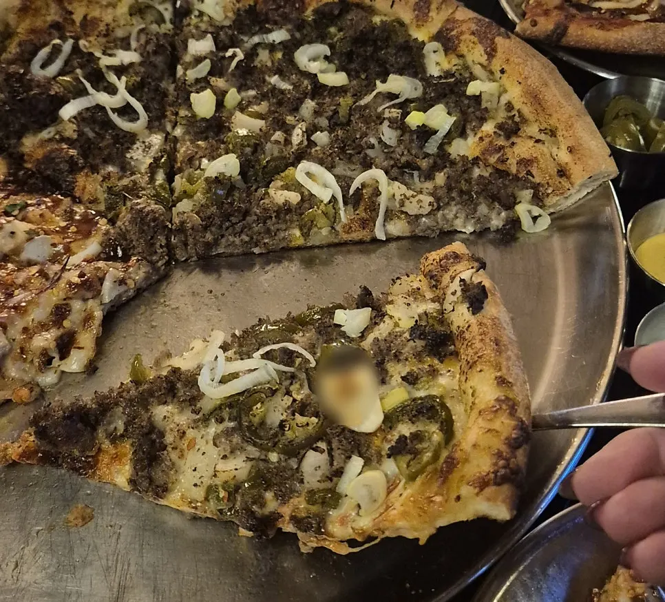 Close-up of beef pizza topped with jalapeños and onions