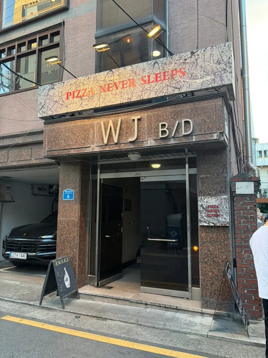 Exterior sign of Pizza Never Sleeps on Songridan-gil