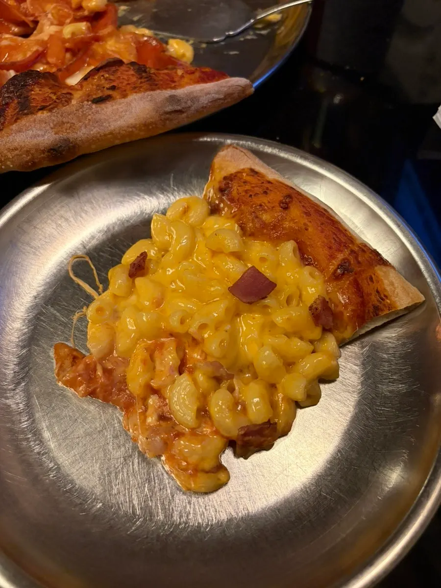 Mac Night pizza slice topped with mac and cheese