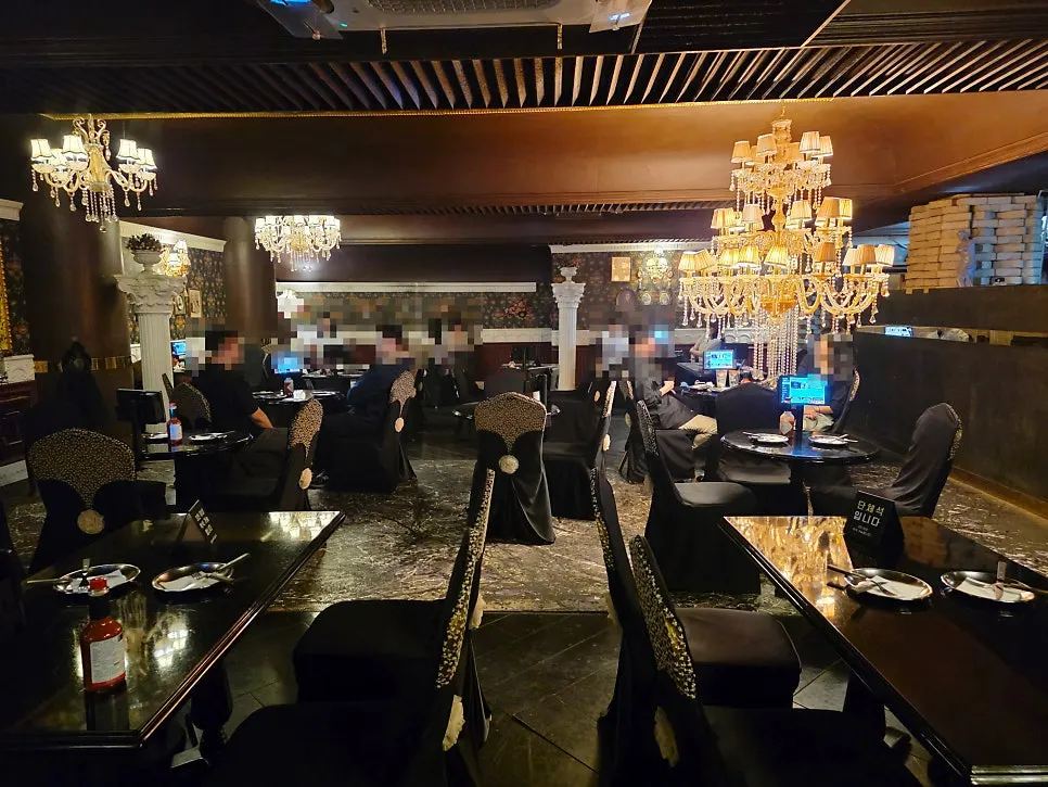 Basement dining room lit by chandeliers