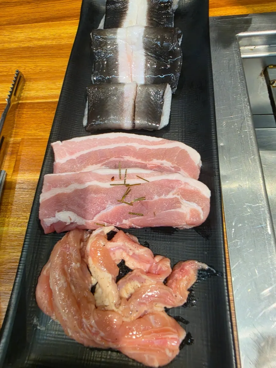 Table set with eel and meat ready for grilling