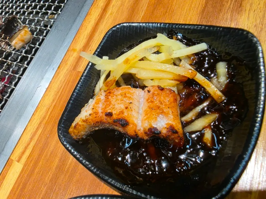 Eel topped with shredded ginger in teriyaki sauce
