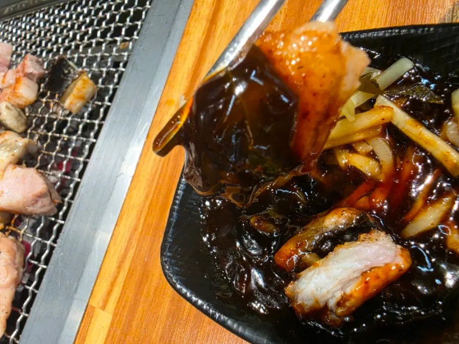 A bite of eel plated together with side garnishes