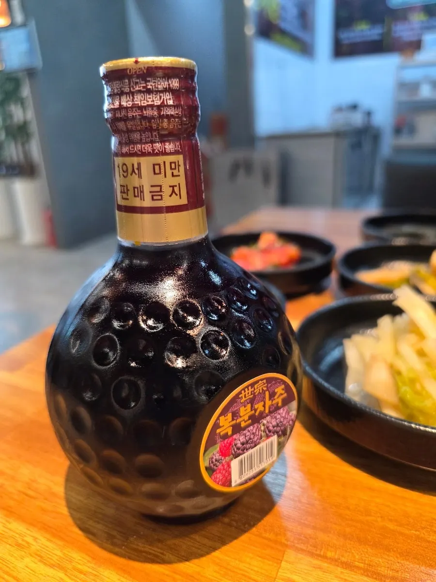 A bottle of bokbunja served free with the all-you-can-eat order
