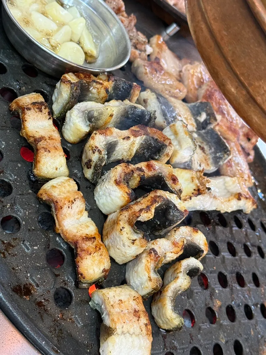 Freshwater eel grilling to a golden brown on the pan