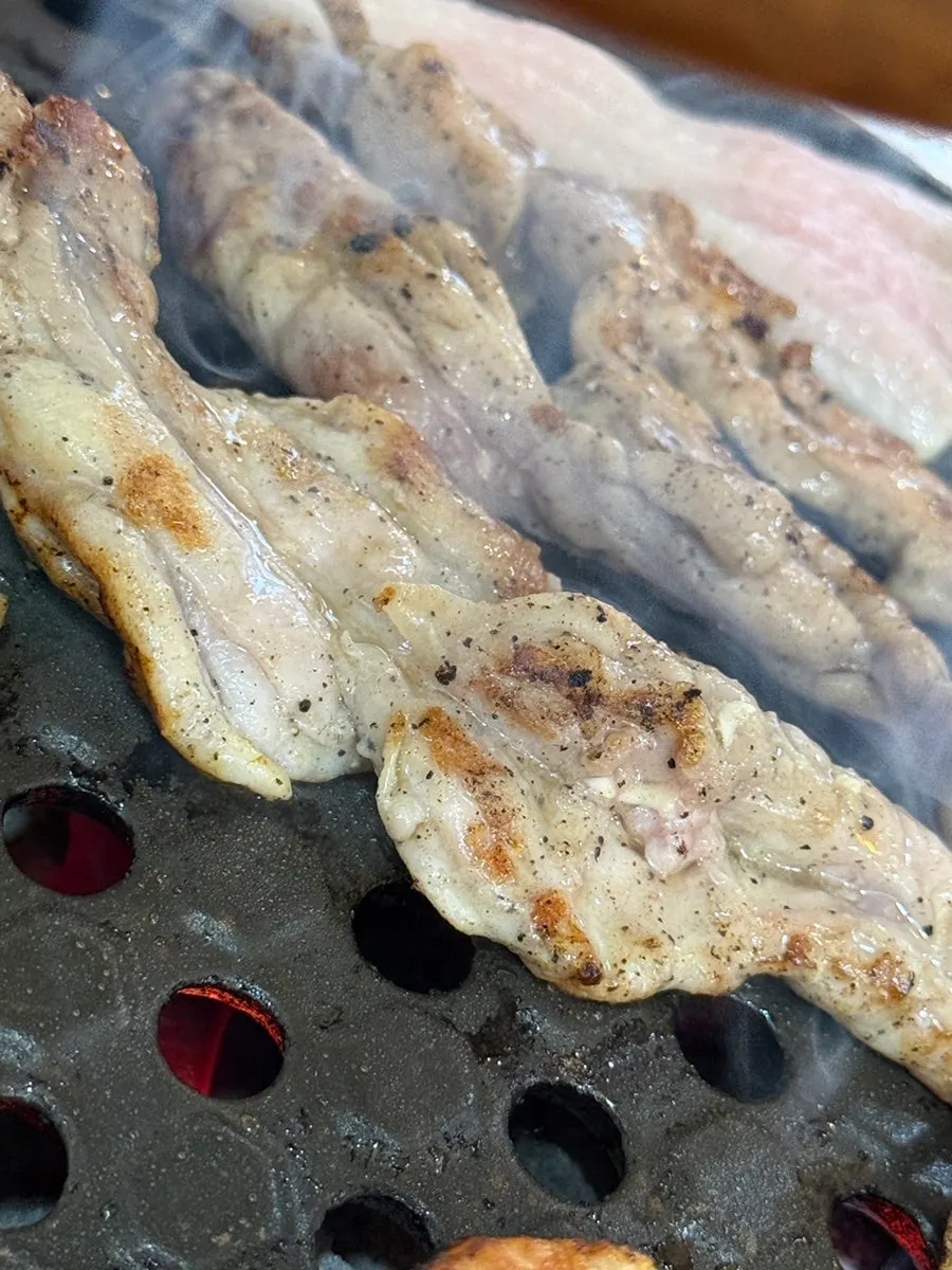 Pork belly being dipped in spicy sauce