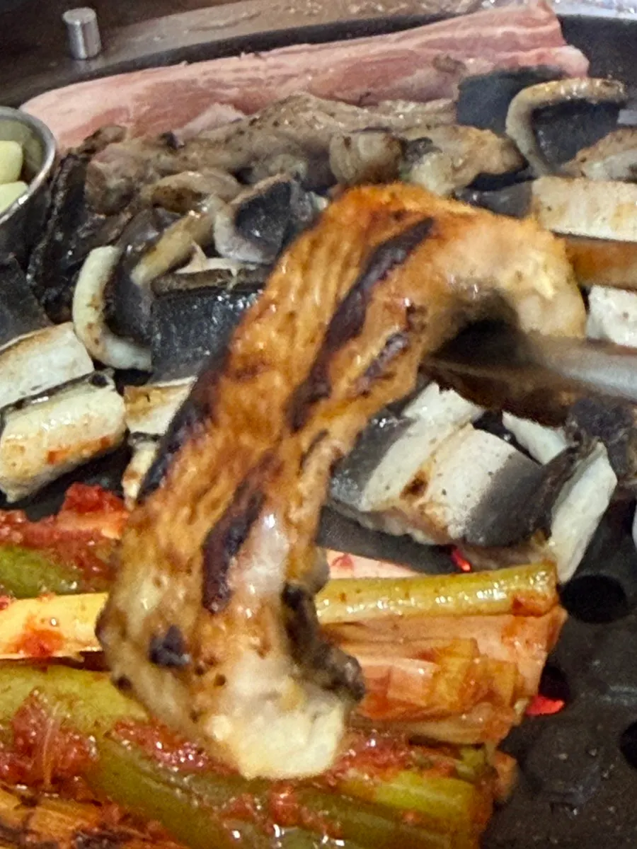 Grilled green onions served with white kimchi and pickled onion