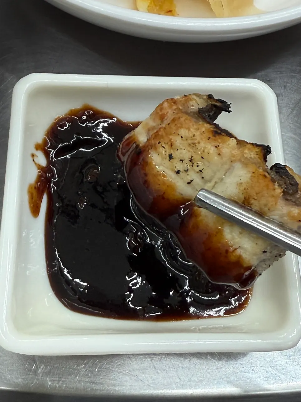 A piece of charcoal-grilled eel dipped in sauce