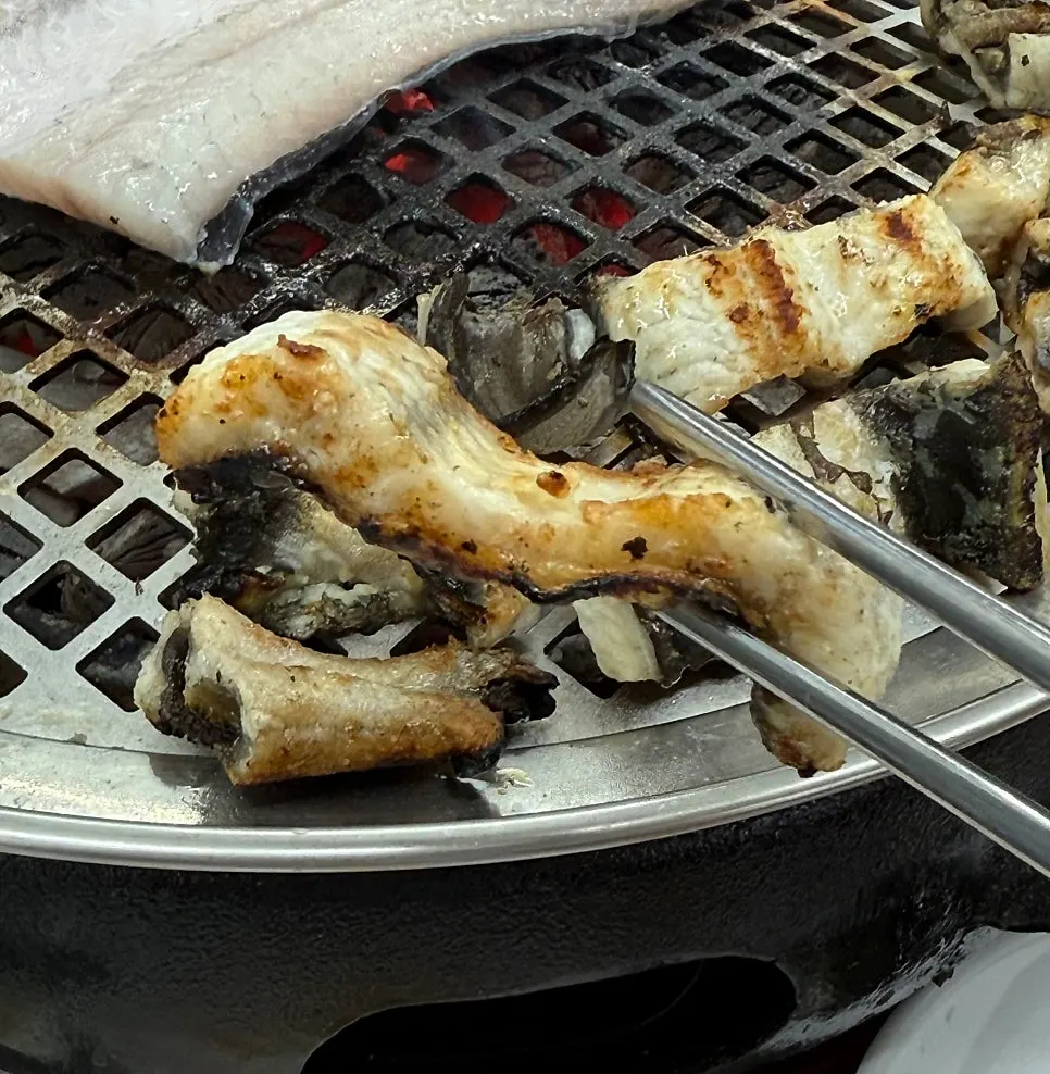 A charcoal grill loaded with eel and meat