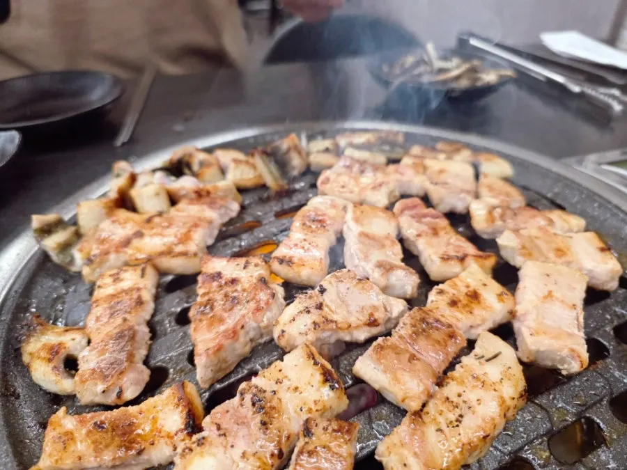 All-you-can-eat pork belly cooking on the grill