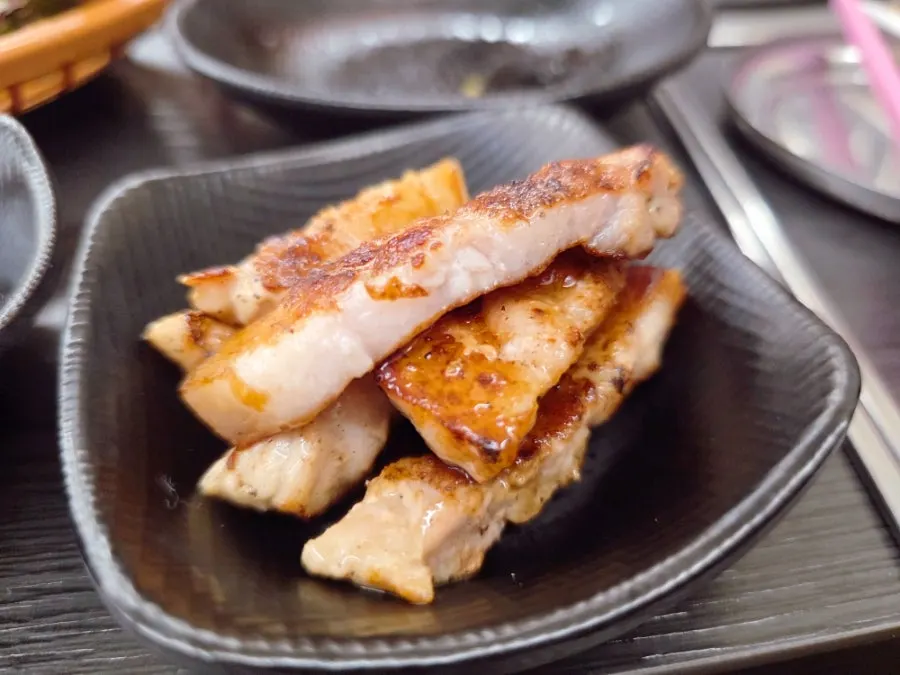 Eel and pork belly grilling together on the pan