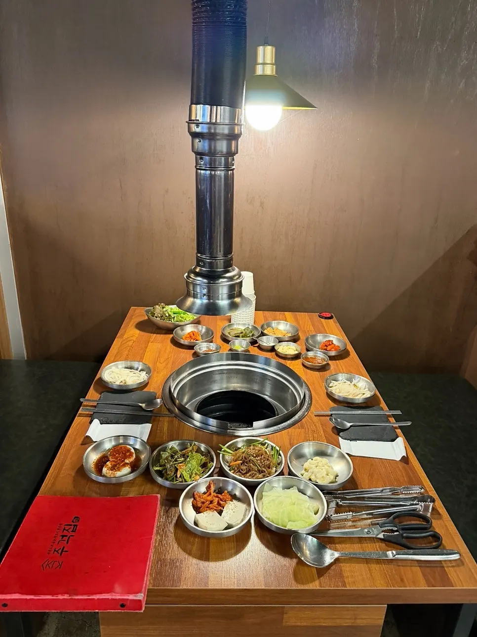 주걱집 홀에 길게 놓인 단체 테이블과 셀프바