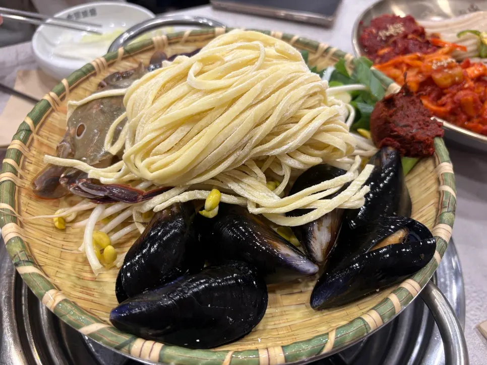 Clear seafood kalguksu with mussels and blue crab