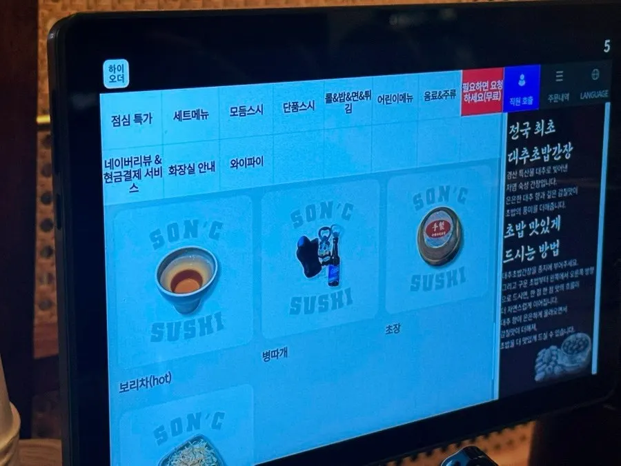 테이블 태블릿으로 메뉴를 고르는 모습