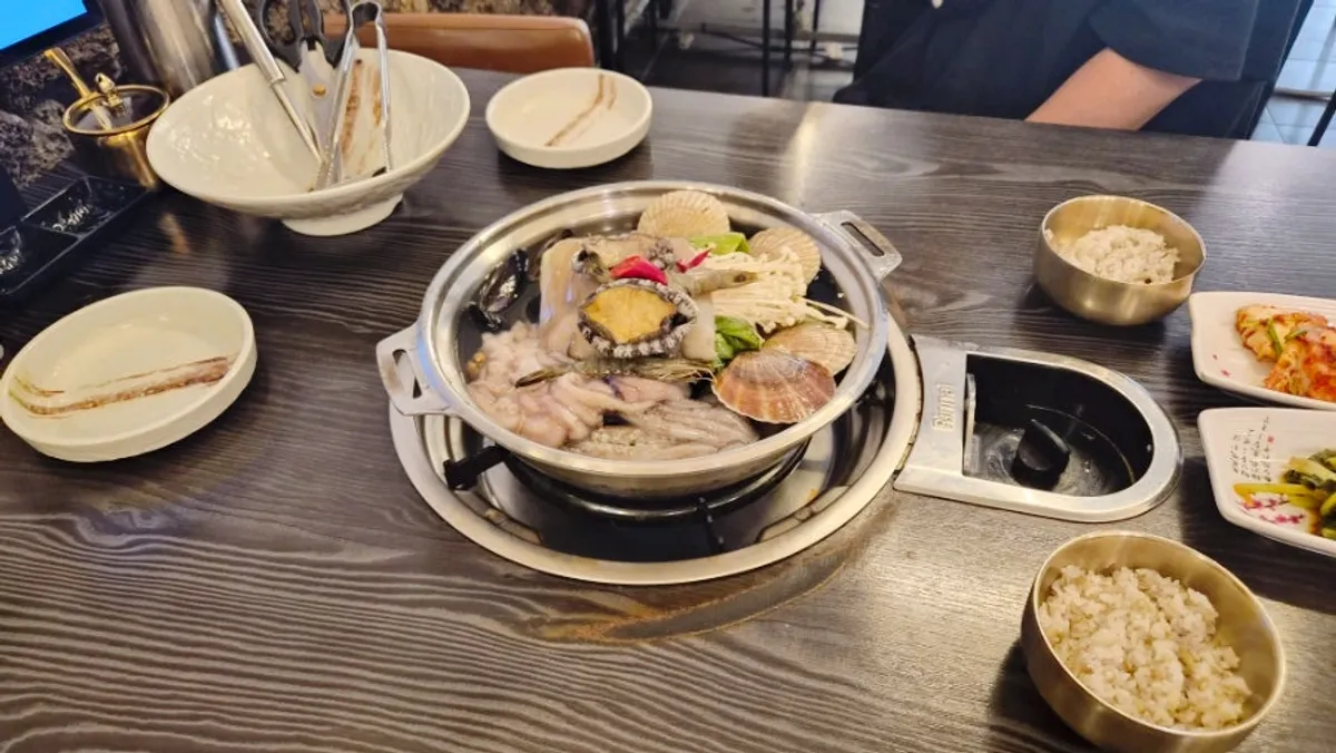 A full spread of Sonson Seafood Kalguksu piled with seafood