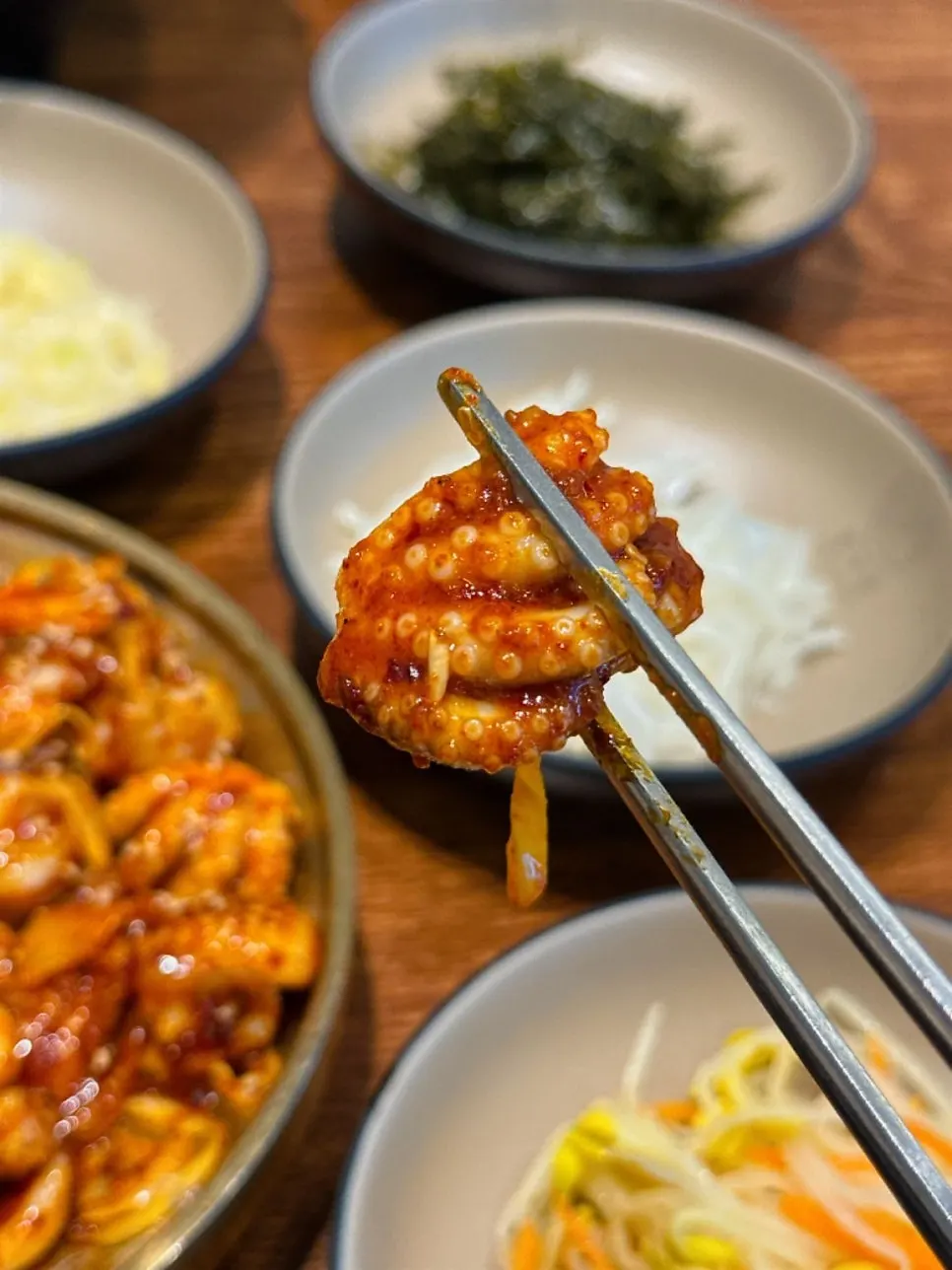 젓가락으로 집어 든 쭈꾸미 한 점