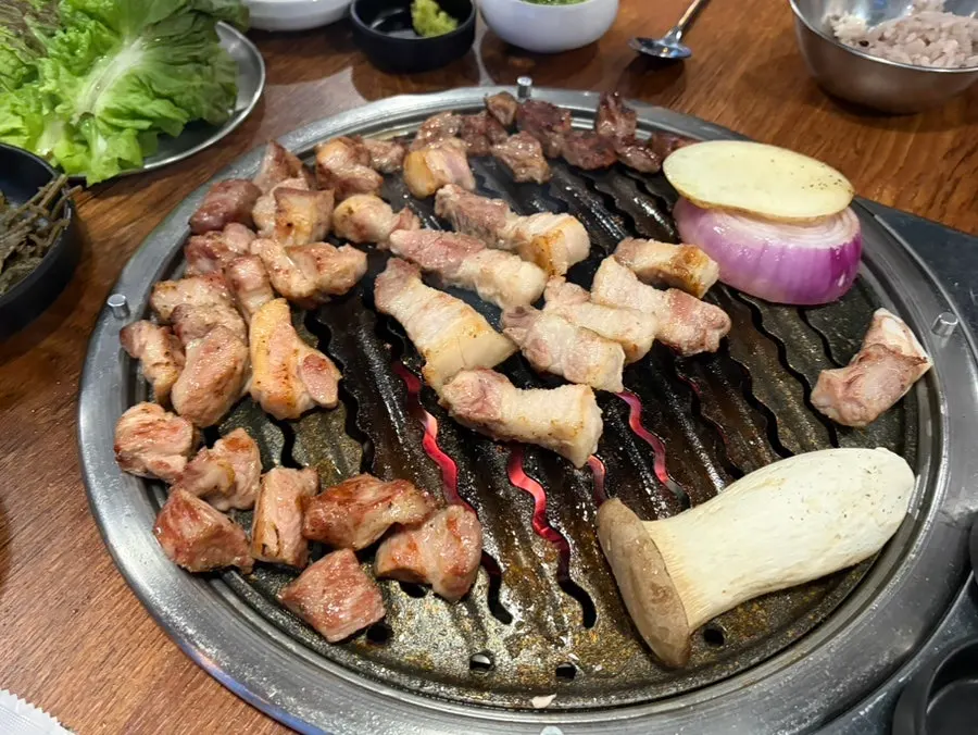 Staff grilling thick pork neck and pork belly