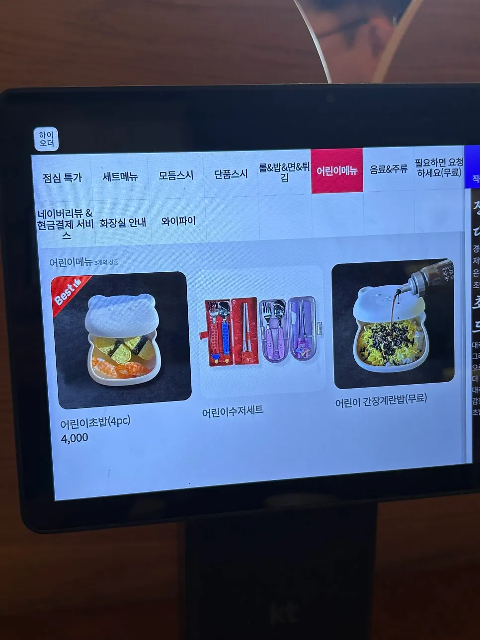 Menu board listing kids' sushi and soy sauce egg rice