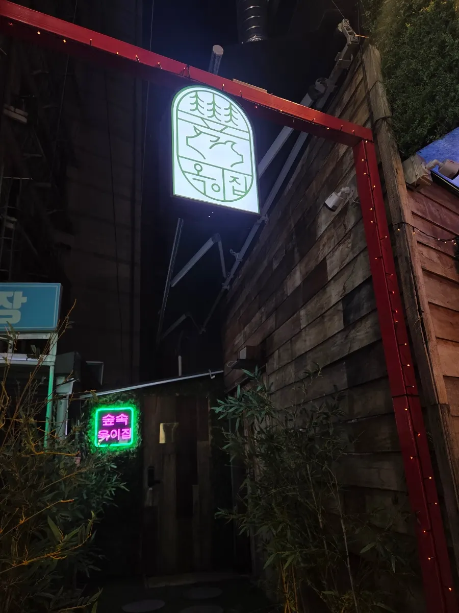 나무와 초록 식물로 꾸민 매장 입구