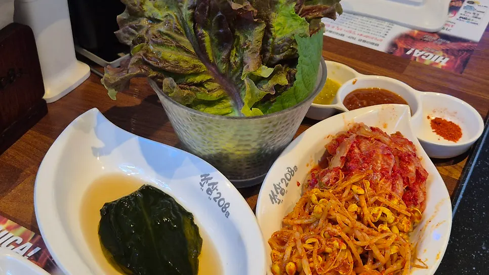 Basic side dish spread with wild garlic greens, lettuce wraps, kimchi, and seasoned bean sprouts